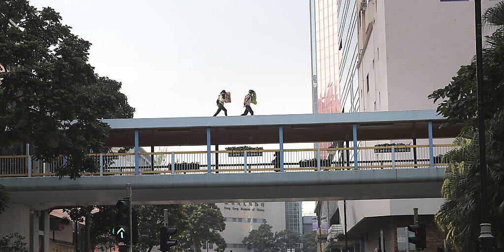 Demonstranten flüchten vom Universitätsgelände über das Dach einer Fussgängerbrücke.