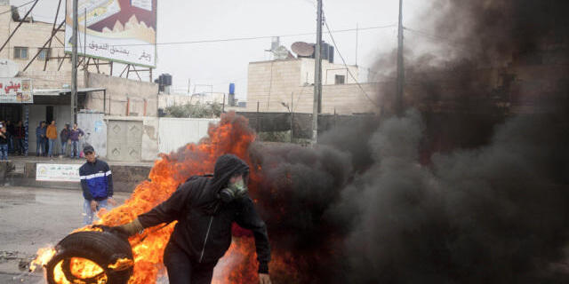 Ein Palästinenser wirft bei Ramallah einen brennenden Reifen