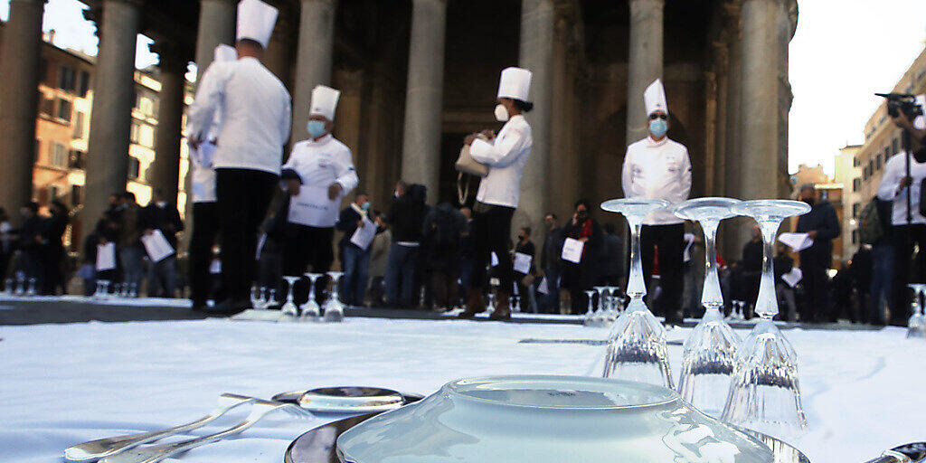 dpatopbilder - Köche und Restaurantbesitzer haben auf dem Boden liegende Decken mit Geschirr gedeckt und nehmen in Arbeitskleidung an einem Protest gegen die Maßnahmen der Regierung zur Eindämmung der Corona-Pandemie auf dem Platz vor dem Pantheon teil. Foto: Alessandra Tarantino/AP/dpa dpatopbilder - Köche und Restaurantbesitzer haben auf dem Boden liegende Decken mit Geschirr gedeckt und nehmen in Arbeitskleidung an einem Protest gegen die Maßnahmen der Regierung zur Eindämmung der Corona-Pandemie auf dem Platz vor dem Pantheon teil. Foto: Alessandra Tarantino/AP/dpa