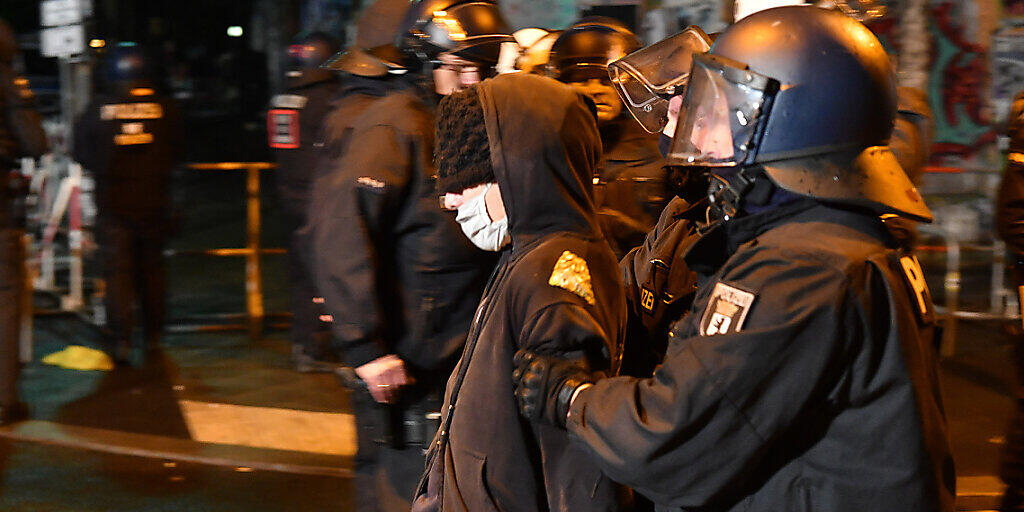 dpatopbilder - Polizisten führen in der Rigaer Straße einen Demonstranten ab, der gegen die Räumung des besetzten Hauses «Liebig 34» protestieren. Foto: Paul Zinken/dpa