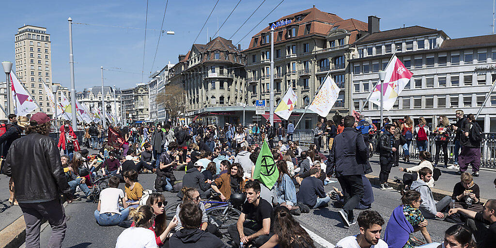 Klimaaktivisten haben sich am Donnerstag in Lausanne mitten auf die Fahrbahn der Grand-Pont-Brücke gesetzt, um ihr Mittagessen einzunehmen und gegen die Umweltzerstörung zu protestieren.