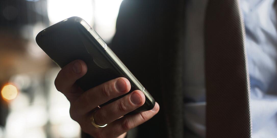 Businessman in suit, jacket,shirt, tie, using his smart phone