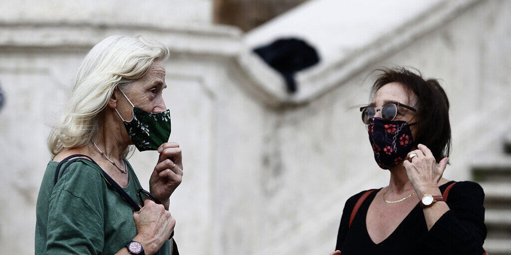 ARCHIV - Menschen mit Mund-Nasen-Schutz stehen vor einer Treppe in Rom. Angesichts landesweit steigender Zahlen von Corona-Neuinfektion führt Italien eine Maskenpflicht im Freien ein. Foto: Cecilia Fabiano/LaPresse via ZUMA Press/dpa ARCHIV - Menschen mit Mund-Nasen-Schutz stehen vor einer Treppe in Rom. Angesichts landesweit steigender Zahlen von Corona-Neuinfektion führt Italien eine Maskenpflicht im Freien ein. Foto: Cecilia Fabiano/LaPresse via ZUMA Press/dpa