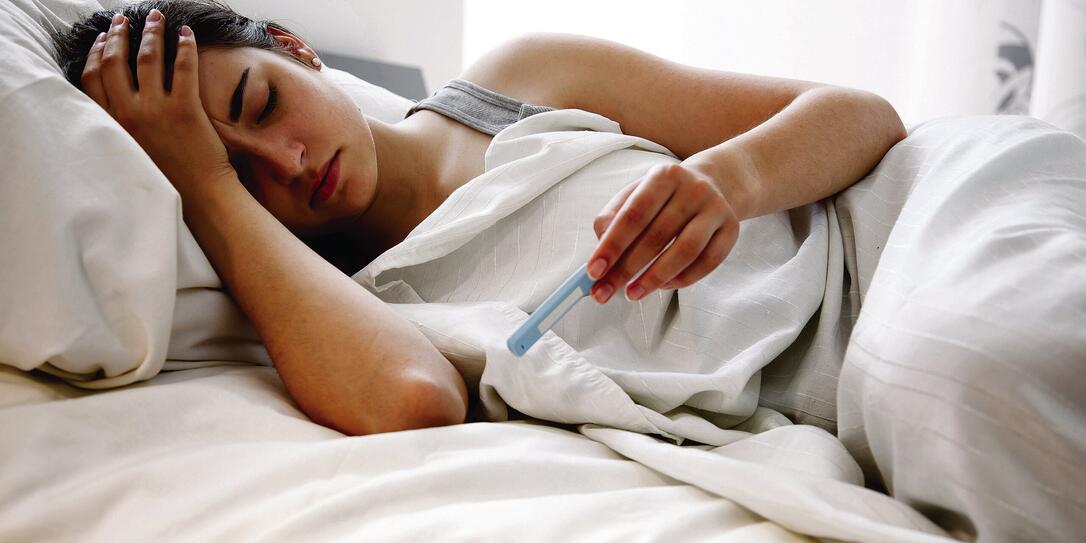 Woman Checking Her Temperature in Bed