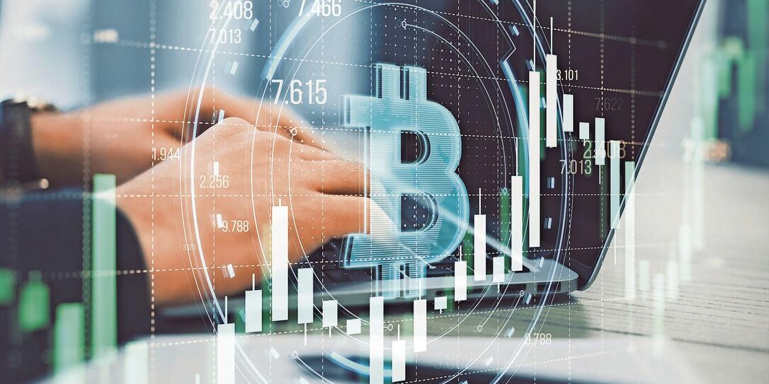Close up of male hands using laptop with creative round bitcoin hologram on blurry grid background with forex chart. Online banking, cryptocurrency and finance concept. Double exposure.
