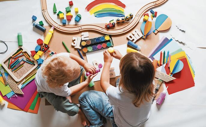 Children drawing and making crafts in kindergarten or daycare.