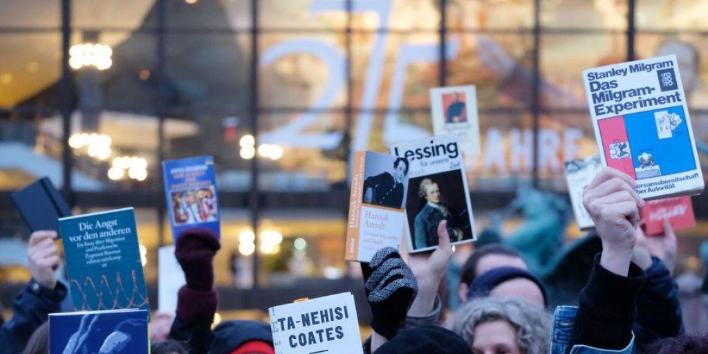 Teilnehmer einer Demonstration halten auf dem Augustusplatz in Leipzig Bücher in die Höhe. Etwa 200 Menschen protestierten gegen die Präsenz rechter Verlage auf der Leipziger Buchmesse.