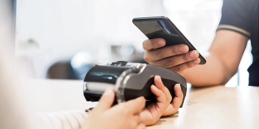 Customer using phone for payment to owner at cafe restaurant, cashless technology and credit card payment concept