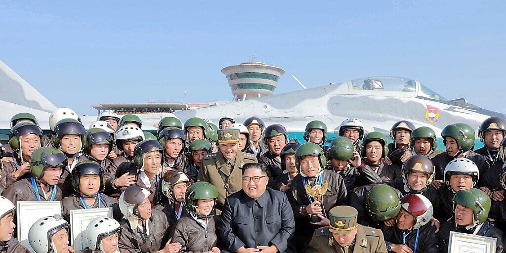 Nordkoreas Machthaber Kim Jong Un posiert mit Armeeangehörigen während Luftübungen der Streitkräfte.