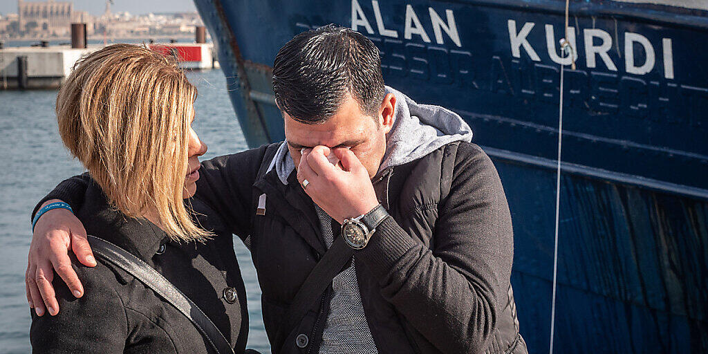 ARCHIV - HANDOUT - Der Vater (r) von Alan Kurdi steht bei der Taufe vor dem Rettungsschiff von Sea Eye auf den Namen seines Sohnes. Alan Kurdi war ein dreijähriger syrischer Junge kurdischer Abstammung, dessen Leiche 2015 an einen türkischen Strand angespült worden ist. Foto: Maik Lüdemann/Sea Eye/dpa - ACHTUNG: Nur zur redaktionellen Verwendung und nur mit vollständiger Nennung des vorstehenden Credits