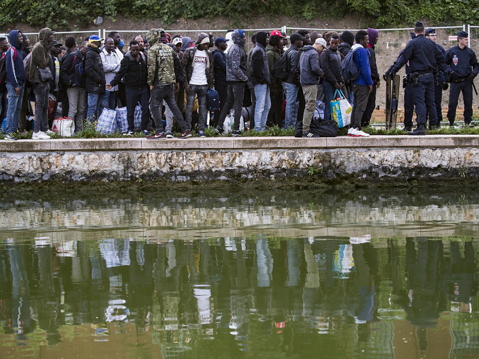Flüchtlinge stehen Schlange, um in Unterkünfte in Paris oder der Umgebung gebracht zu werden. Seit Monaten hatten sich immer mehr Migranten an den Ufern zweier Kanäle im Nordosten der französischen Hauptstadt angesiedelt.