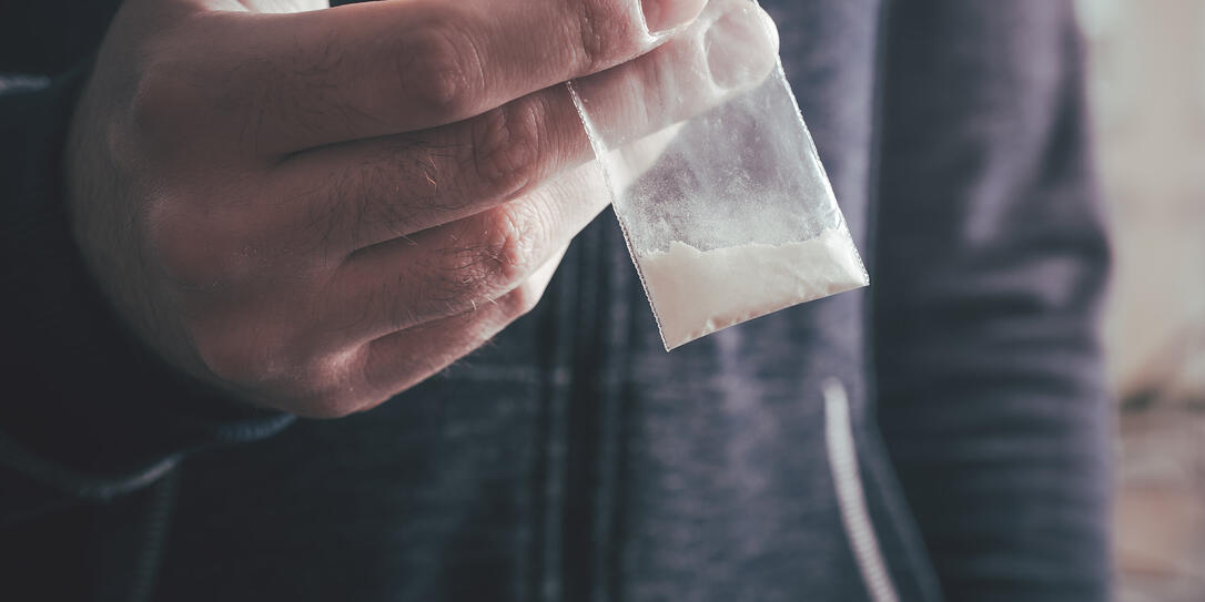 Dealing Drugs By A Man Holding A Little Bag With White Powder In His Hand