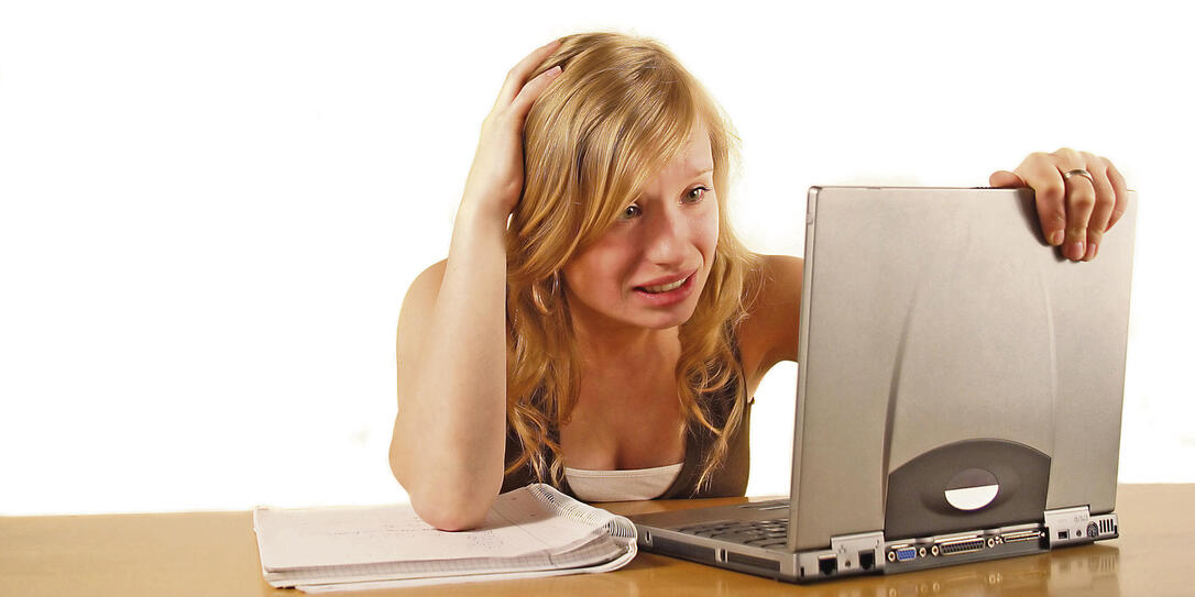 Frau verzweifelt mit Notebook