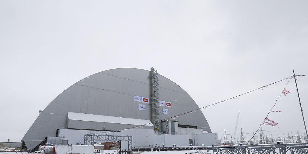 Die neue Schutzhülle um die Atomruine in Tschernobyl steht. Sie wurde mit einem Hydrauliksystem auf Spezialschienen über den havarierten Reaktor geschoben.